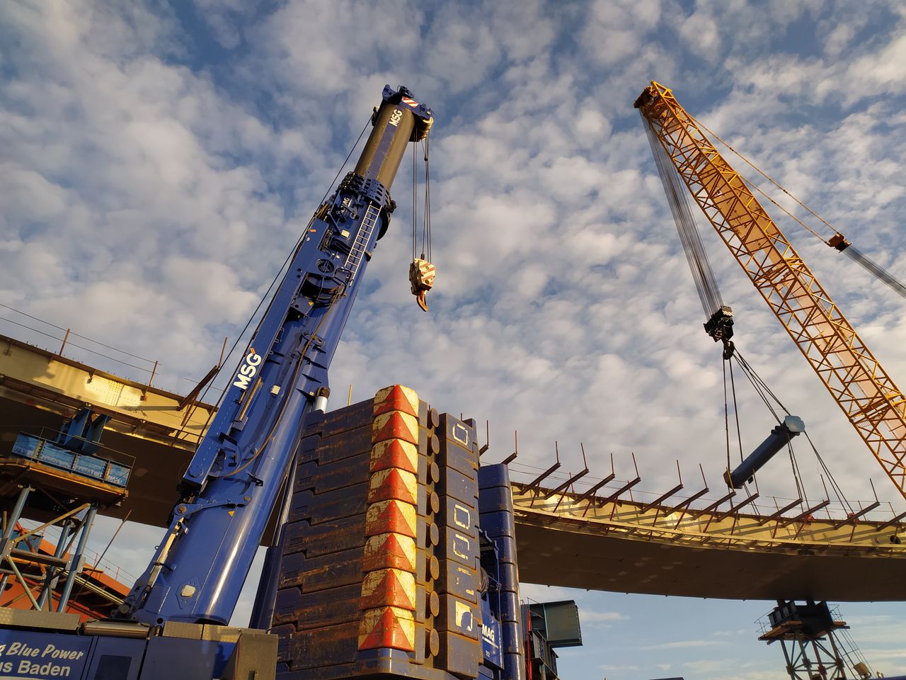 Elevated view of construction cranes and heavy machinery at a Moscow worksite under a cloudy sky.